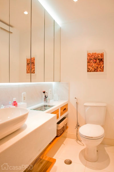 Iluminação indireta e toques de madeira marcam este banheiro. Projeto de Carolina Danielian.