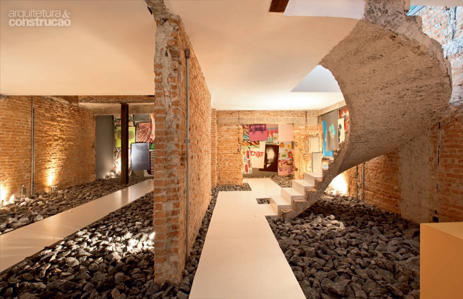 ESTRUTURA EXPOSTA. O casarão dos anos 40 viu seu passado revelado após a intervenção encomendada ao FGMF Arquitetos. Lixadas, as paredes agora exibem os tijolos com que foram construídas. Já a escada perdeu os acabamentos até restar sua silhueta escultural de concreto. Nas laterais, ilhas com rachão de granito sugerem que o visitante siga o caminho de resina de poliuretano, com 90 cm de largura. “O percurso imaculado cria um contraste com o visual de demolição em volta. Essa proposta cenográfica foi possível por se tratar de um ambiente comercial. Mas vale também para uma residência, desde que com mais parcimônia e a mistura de materiais novos”, explica Fernando Forte, um dos sócios do escritório. ESTRUTURA EXPOSTA. O casarão dos anos 40 viu seu passado revelado após a intervenção encomendada ao FGMF Arquitetos. Lixadas, as paredes agora exibem os tijolos com que foram construídas. Já a escada perdeu os acabamentos até restar sua silhueta escultural de concreto. Nas laterais, ilhas com rachão de granito sugerem que o visitante siga o caminho de resina de poliuretano, com 90 cm de largura. “O percurso imaculado cria um contraste com o visual de demolição em volta. Essa proposta cenográfica foi possível por se tratar de um ambiente comercial. Mas vale também para uma residência, desde que com mais parcimônia e a mistura de materiais novos”, explica Fernando Forte, um dos sócios do escritório.