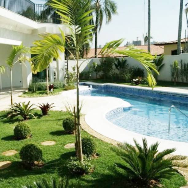 O deck em madeira separa o jardim da piscina. Plantas das espécies buxinhos, palmeiras elegans, cicas, ravenalas, moreias e orquídeas bambu completam o jardim. O projeto foi feito em uma casa pela arquiteta Carla Prado Dadazio.