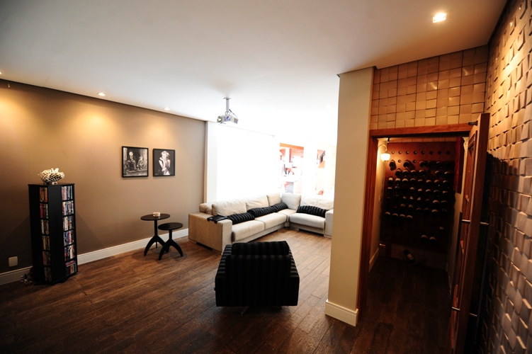 Nesta área de home theater (com metragem de 25m²), a arquiteta Daniele Cardoso usou um piso cimentício da linha rústica da Arte Piso com medida especial 1 x 0,20m (também usado na área da cozinha desta mesma casa).