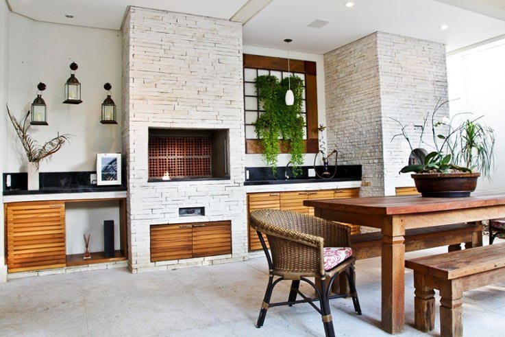 O ponto de partida para a churrasqueira desta casa em São Paulo foi a própria arquitetura do imóvel: leve, com estilo clean e moderno.  O jardim vertical é composto por uma moldura de madeira com quadriculados de ferro da parede, que recebeu vasos de dinheiro-em-penca. Projeto da arquiteta Andrea Balastreire. Paisagismo de Julio Anjos.