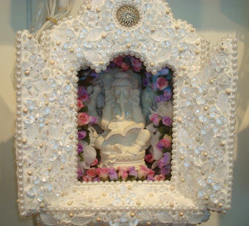 A Santo de Casa apresenta divindades de resina em caixinhas de madeira e massa corrida, enfeitadas com cristais e miçangas. São santos de todas as religiões - de Maria a Buda.