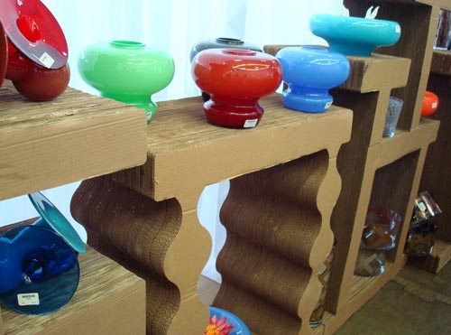 A linha Sebuso foi desenvolvida pela designer Flávia Alves de Sousa para a Objecto de Desejo. Os vasos de vidro são produzidos com técnica de murano. As estantes em que são exibidas as peças é feita de papelão reciclado.
