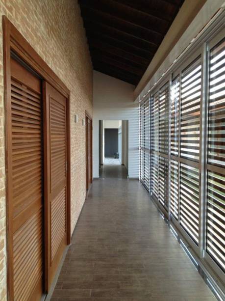 CASA EM JUNDIAÍ. Neste corredor da casa de campo, projetada por Juliana Sorolla Mancini, é possível perceber o bom aproveitamento da iluminação natural no interior da residência. Este foi um dos principais pedidos dos clientes para a profissional, que ainda precisou integrar a construção com a área externa.