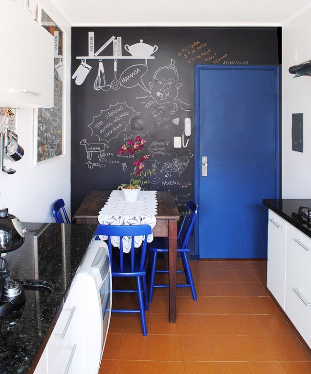 “Na reforma desta cozinha removemos os antigos azulejos da parede e mantivemos o piso. Nas paredes: lousa em esmalte acetinado preto, painel de cerâmicas coloridas sobre cooktop e todo o restante em branco. Esquadrias em azul intenso para contraste.”, diz Thais Lenzi.