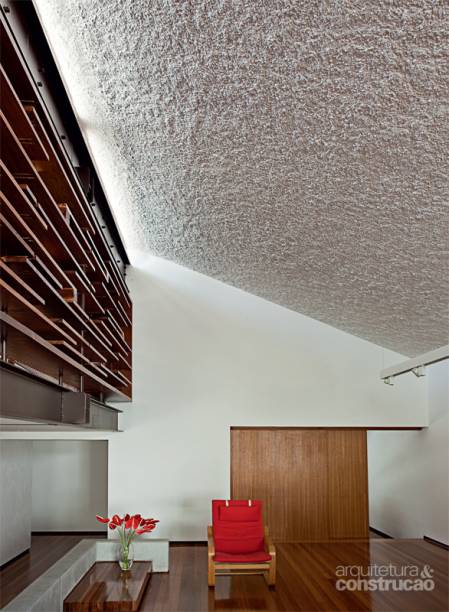 CHAPISCO CHIQUE. Lá em cima, um rasgo de vidro de 30 cm de altura deixa passar a iluminação natural que realça o aspecto rugoso do teto inclinado desta casa, assinada pelo arquiteto Vasco Lopes. “O próprio ângulo da laje ajuda a ressaltar esse efeito da luz sobre a superfície de chapisco grosso, mistura de areia, cimento e brita número 1”, diz Vasco. Também da comparação com a parede lisa nasce a força visual desse revestimento tão simples, um hit da construção civil. “A vantagem desse tipo de acabamento é não depender de modismos: passa pelo tempo sem cansar.” A única intervenção foi a pintura com tinta látex branca. “Prefira um rolo de pelo longo para preencher as irregularidades.” Obra executada pela SBN Engenharia. CHAPISCO CHIQUE. Lá em cima, um rasgo de vidro de 30 cm de altura deixa passar a iluminação natural que realça o aspecto rugoso do teto inclinado desta casa, assinada pelo arquiteto Vasco Lopes. “O próprio ângulo da laje ajuda a ressaltar esse efeito da luz sobre a superfície de chapisco grosso, mistura de areia, cimento e brita número 1”, diz Vasco. Também da comparação com a parede lisa nasce a força visual desse revestimento tão simples, um hit da construção civil. “A vantagem desse tipo de acabamento é não depender de modismos: passa pelo tempo sem cansar.” A única intervenção foi a pintura com tinta látex branca. “Prefira um rolo de pelo longo para preencher as irregularidades.” Obra executada pela SBN Engenharia.