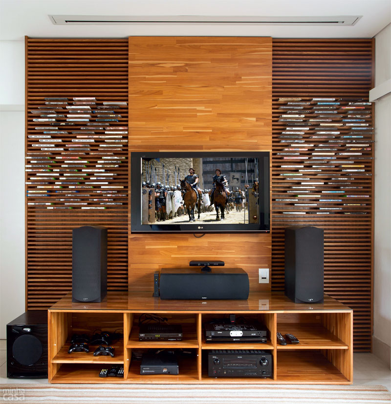 ENCAIXE PERFEITO E DE EFEITO. Reunir e manter &agrave; vista, sem bagun&ccedil;a, as prefer&ecirc;ncias de um casal e de seus tr&ecirc;s filhos no home theater n&atilde;o &eacute; nada simples. &ldquo;Quer&iacute;amos uma estante pr&aacute;tica, que n&atilde;o desse muito trabalho para organizar&rdquo;, lembra a enfermeira Luciane Rossi, de Jandira, SP. Fugindo das prateleiras convencionais, a arquiteta Adriana Victorelli ladeou a TV com dois pain&eacute;is ripados de 89 cm de largura cada (Philadelphia Marcenaria, R$ 6300 com pain&eacute;is e rack de teca).