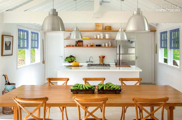 Na moradia em que fica a área social, a cozinha é aberta para o estar. A ilha de marmoglass (1,45 x 2,80 m, da Apicoar) embute o cooktop. Projeto de André Luqu para uma casa de campo no Rio de Janeiro.