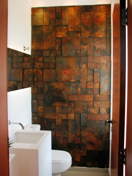CASA EM JUNDIAÍ. O lavabo de 2, 5 m², da casa projetada por Juliana Sorolla Mancini, traz um revestimento diferente na parede: placas cimentícias (Castelatto, linha Oxyden). Completando o ambiente, o piso é de porcelanato (Eliane 59x59) e as paredes receberam tinta acrílica fosca (branco neve).