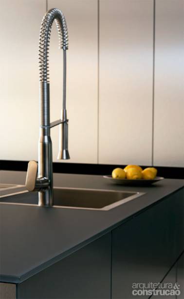 Aço + vidro, sem furos. A dupla dá certo em novas bancadas do tipo ilha. É conhecida no ramo a dificuldade de somar uma chapa de vidro a uma pia de inox – e obter vedação perfeita. A Kitchens chegou lá. O tampo de 12 mm Carbon (em cinza, temperado e dotado de película  protetora na face inferior) possui as bordas rebaixadas para a sobreposição minuciosa das abas da cuba. Com alinhamento preciso, não há  frestas por onde entrem água ou restos de alimentos. A ilha da foto (tampo, armários, duas cubas e torneiras) tem preço inicial de R$ 50 mil.