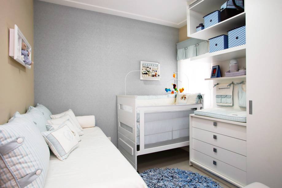 Em uma área de 12,55m² a arquiteta Orlane Santos começou com o papel de parede de fundo com textura agradável ao toque. O móvel, que uniu trocador e armário, foi o coringa do projeto: o armário tem porta de correr para que possa ser colocado o trocador, a cama da babá, o berço e a poltrona. Essa medida mantém uma boa circulação e faz com que sobre espaço para o bebê brincar quando crescer. O berço vira cama e o tapete personalizado leva todas as cores do ambiente.