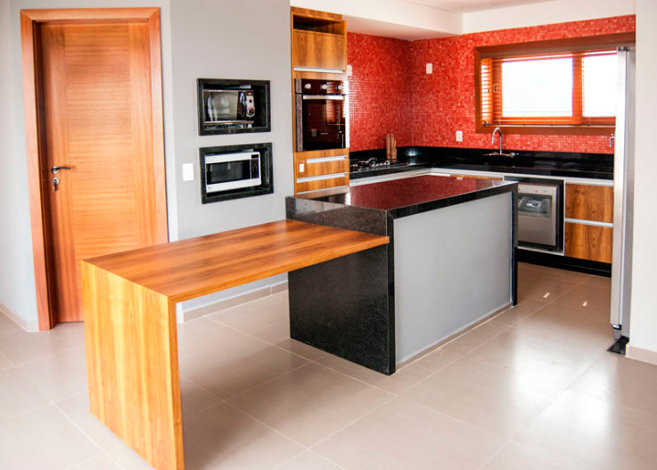 CASA EM JUNDIAÍ. Na cozinha da casa de campo projetada por Juliana Sorolla Mancini, a mistura de materiais deu certo. O ambiente, de 22 m², traz bancada de granito preto são gabriel, pastilhas de vidro vermelhas (Colormix, linha vidrepur) e marcenaria planejada.