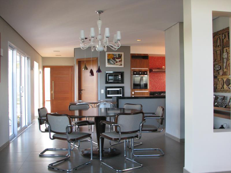 CASA EM JUNDIAÍ. A sala de estar, lareira, jantar e cozinha são integradas na casa de campo projetada por Juliana Sorolla Mancini, formando um ambiente de 75 m². Neste ângulo da foto, é possível observar a sala de jantar e um pedaço da cozinha. Os dois ambientes têm piso porcelanato (Eliane 59x59).