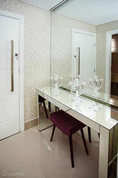 O hall era apertado e escuro, por esse motivo foram realizadas intervenções para criar um ambiente agradável e elegante: foram instalados piso de porcelanato Plaza Off White da Portobelo nas dimensões 60 x 60cm, papel de parede com arabescos e espelho em uma das paredes. O aparador espelhado completou a decoração. Projeto de Maria Isabel Amorim Lavrini.