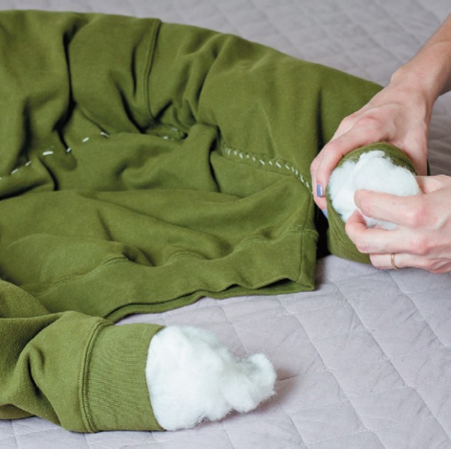 Pela abertura dos punhos, insira manta acrílica, espuma picada ou até mesmo sobras de tecidos. Deixe bem fofinho, pois esta parte servirá como borda da cama.