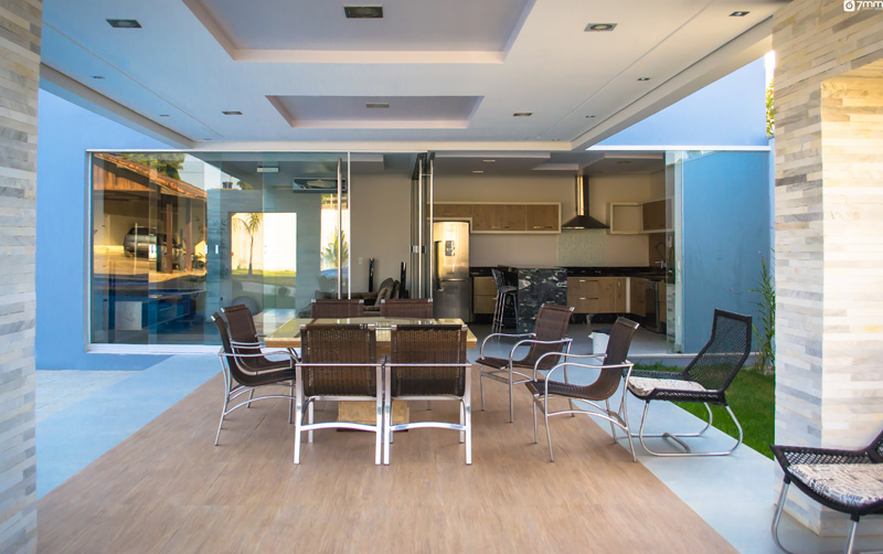 O ambiente projetado pelo arquiteto Ricardo Galego é uma varanda integrada à área externa que abriga a piscina e o home theater. Para que as três áreas pudessem ser usadas à parte, o arquiteto optou por separá-las com uma parede de vidro móvel que, quando fechada, pode dar privacidade e ajuda na climatização interna do ambiente.