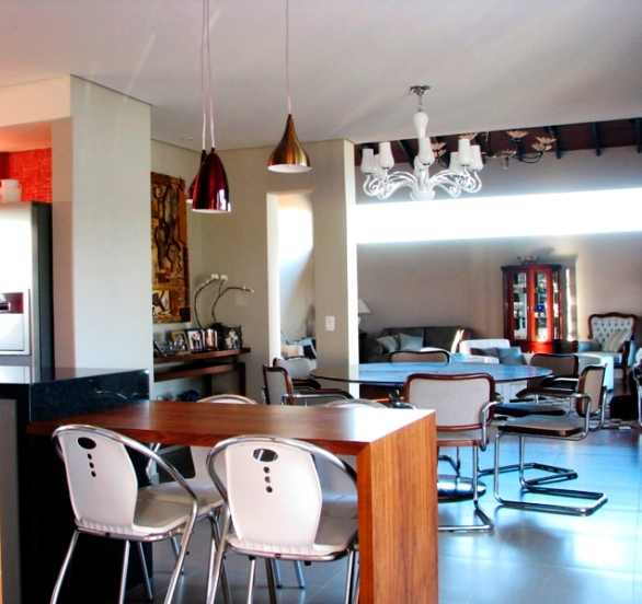 CASA EM JUNDIAÍ. Vigas aparentes de madeira itaúba no teto separam o jantar da sala principal, na casa de campo projetada pela arquiteta Juliana Sorolla Mancini. O ambiente principal também recebe piso de madeira cumaru (Zanchet).