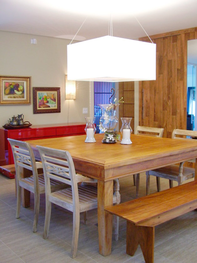 A mesa da sala de jantar desta casa de campo tem cadeiras de um lado e um banco de madeira de outro. Projeto de Rosane Aguiar.