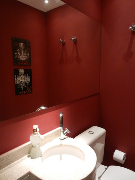 O lavabo projetado por Andrea Lenz utiliza o vermelho em todas a paredes. Para contrapor o tom forte, a bancada, as louças e teto são brancos.