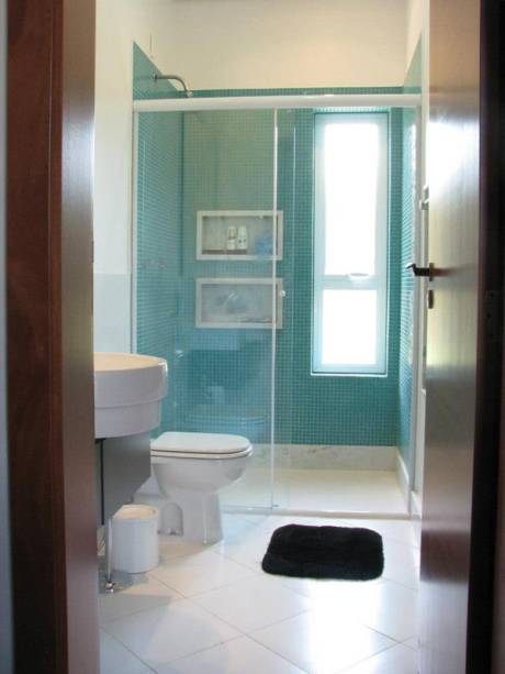 CASA EM JUNDIAÍ. O banheiro da suíte projetada por Juliana Sorolla Mancini traz pastilhas de vidro turquesa, que contrastam com o branco presente no resto do ambiente de 5 m². Mármore branco espírito santo foi utilizado no rodapé, bancada e nos nichos do boxe.