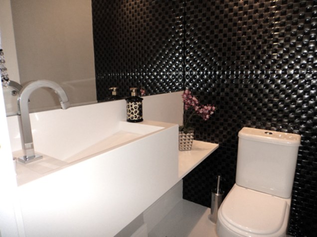 Paredes pretas e detalhes em branco criam uma atmosfera cosmopolita neste lavabo projetado por Andrea Balastreire para um apartamento em Pinheiros.