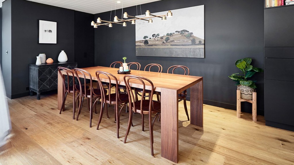 Sala de jantar; piso laminado; mesa de madeira; parede preta