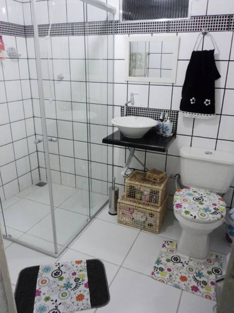 Leitora de Minha Casa, Wanneska Nascimento aproveitou as dicas da revista na hora de projetar seu banheiro. Uma sacada da moradora foi colocar rodinhas no gabinete, o que facilita na hora de limpar e mudar a decoração do ambiente. Na disposição que está na foto, o gabinete deu lugar às caixas organizadoras embaixo da pia. Dica da redação: note que fofo o jogo de tapete que a moradora utilizou. Ela troca conforme as datas comemorativas, tem até um de Natal!