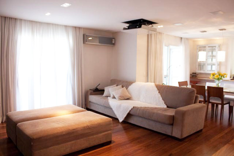 A sala de 35 m&sup2; integra a sala de jantar e o home theater com tel&atilde;o embutido. Para deixar os dois ambientes com a mesma cara, mas sem misturar suas fun&ccedil;&otilde;es, a arquiteta Beatriz Aguiar utilizou a mesma paleta de cores em todo o espa&ccedil;o.