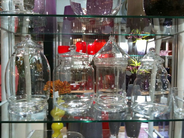 Potes de vidro transparente em modelos vintage, com direito à tampinha e tudo. O terceiro parece até um carrossel, não? Da Toyland.