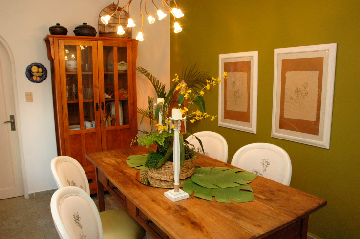 Madeira e tons de verde marcam a decoração desta sala de jantar projetada pela arquiteta Rosane Aguiar.