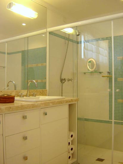 O desafio da arquiteta Ana Paula Barros e da designer de interiores Myriana Abrahamsson para este projeto era reformar o banheiro de 6,42m2 para um casal de 3ª idade. Para isso, a arquiteta optou por usar tons de bege e azul. O box recebeu revestimento até 1,90m de altura – destaque vai para faixa de mármore entre as pastilhas. No restante do banheiro, a parede foi revestida por um rodapé alto, um detalhe de pastilha e acabamento com o filete. O gabinete, feito em mdf, foi dividido para atender separadamente o casal.