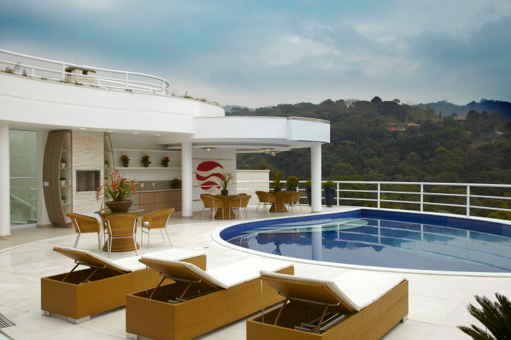 CASA NA SERRA DA CANTAREIRA. A área da piscina da casa projetada por Aquiles Nicolas Kilaris ocupa 77,36 m². A churrasqueira foi revestida com pedra filetada; e o piso, com porcelanato (Fuoco Bianco, Eliane, 45x45).