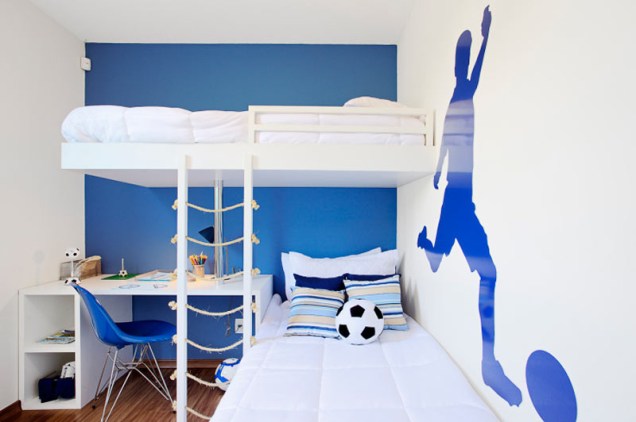 Com um investimento mínimo, os arquitetos Marcelo Sesso e Débora Dalanezi personalizaram este quarto com dois detalhes: pintaram a parede ao fundo de azul e usaram um PVC brilhante em formato de jogador de futebol na lateral. O tom de azul foi repetido na cadeira e no enxoval.