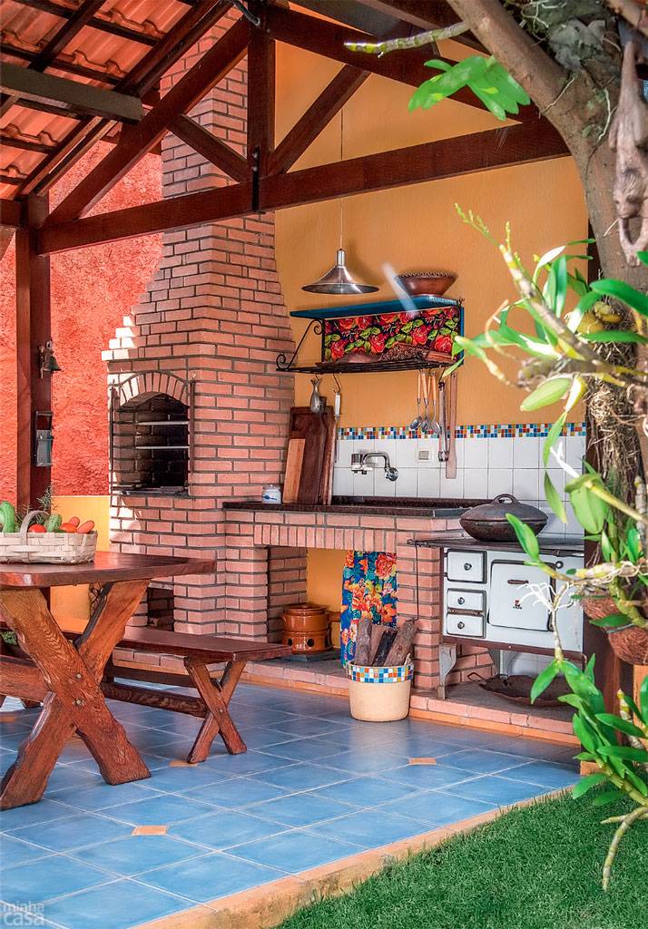 Atra&ccedil;&atilde;o dos fins de semana, o canto do churrasco tem o charme do interior: conta com fog&atilde;o a lenha, ampla mesa de madeira (2 x 0,80 x 0,80 m) e paredes com pintura r&uacute;stica, conquistada com um preparado de &aacute;gua, cal e p&oacute; xadrez amarelo &ndash; para fazer igual, basta juntar os ingredientes e aplicar a mistura na superf&iacute;cie com rolo ou pincel.