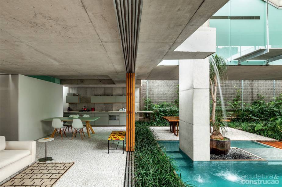 Uma gárgula de concreto entorna, no térreo, o excesso da piscininha particular do casal, formando uma cascata sobre o espelho-d’água construído ali. O volume deste ponto pode ser bombeado de volta até a raia de cima, recomeçando o ciclo. Projeto de Angelo Bucci.