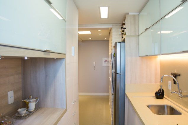 A largura estreita não impediu que a arquiteta Camila Chalon acomodasse vários armários, bancada, geladeira e até uma mini adega nesta cozinha.