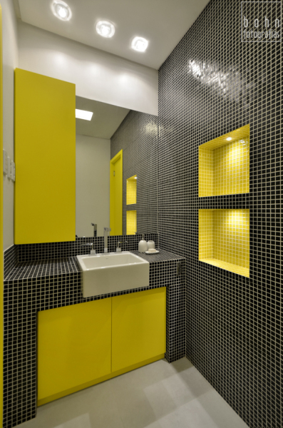Preto e amarelo já é uma combinação ousada para um lavabo. A arquiteta Alessandra Bonotto Hoffmann Paim não só apostou nela, como também na pastilha de vidro.