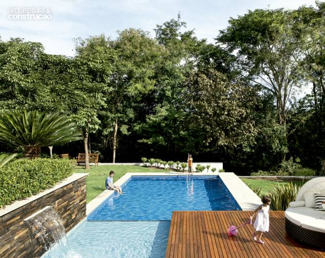 A massa verde lá atrás é uma área de mata preservada, pertencente ao condomínio fechado onde a residência está. Acaba funcionando como uma continuação do jardim de 700 m², que tem deck de ipê e piscina de pastilhas de vidro, compradas na Sicmol. Projeto de Frederico Bretones e Roberto Carvalho. A massa verde lá atrás é uma área de mata preservada, pertencente ao condomínio fechado onde a residência está. Acaba funcionando como uma continuação do jardim de 700 m², que tem deck de ipê e piscina de pastilhas de vidro, compradas na Sicmol. Projeto de Frederico Bretones e Roberto Carvalho.