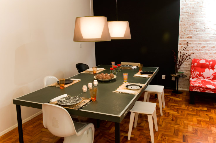 Uma mistura que dá certo: parede preta e cadeiras e bancos de modelos e cores diferentes. Projeto de Ana Paula Magalhães.