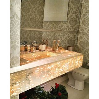 O lavabo deste apartamento residencial foi concebido a partir do tampo de Slimstone Retroiluminado. Com o ponto principal definido, escolheu-se o papel de parede, o piso em porcelanato, e a iluminação. O lavabo, de 3 m², é assinado pela arquiteta Monique Pedruzzi para uma residência em Bento Gonçalves (RS).