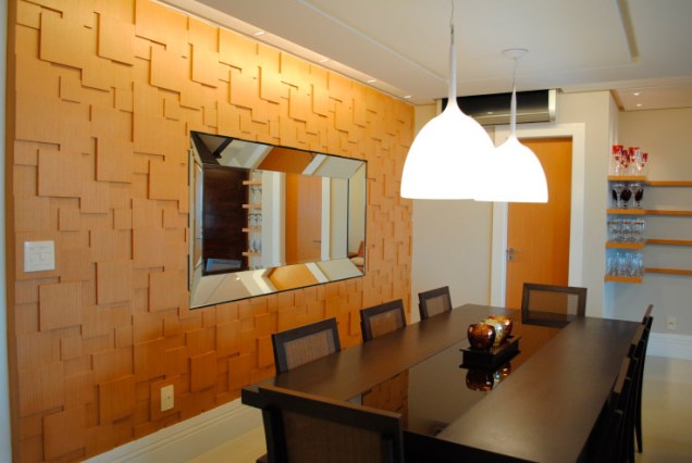A parede é o destaque desta sala projetada pelo escritório OGGI Arquitetura e Ambientação.