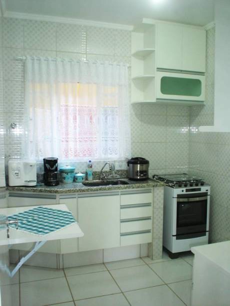 Roberta Novaes de Souza contou com a ajuda da prima arquiteta para decorar a cozinha da sua casa. “Adoro minha cozinha branca. Dá uma sensação de espaço e limpeza”, conta a moradora.  A mesinha também foi uma boa sacada, ée é utilizada para aparar coisas que não cabem na pia.