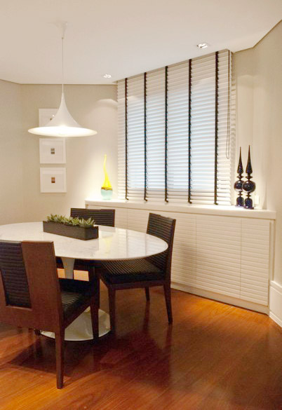 Para este apartamento localizado no bairro de Pinheiros, em São Paulo, a arquiteta Andrea Balastreire optou por uma mesa oval, para disfarçar a planta irregular.