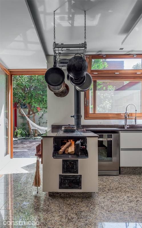 Sonho de consumo da moradora, a cozinha naturalmente clara foi muito bem equipada. Ganhou status de ambiente de conviv&ecirc;ncia, aberta ao terra&ccedil;o e &agrave; sala de estar. Repare no fog&atilde;o a lenha: da Ofcina Victorello, tem partes pr&eacute;-moldadas de concreto e outras de ferro. Projeto da arquiteta Cristina Xavier.
