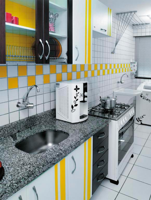 Bastaram dois rolos de adesivo vinílico amarelo e a criatividade da moradora para mudar o visual desse ambiente em Recife - a cor aparece nos armários e também na parede ao fundo, criando um mosaico colorido.