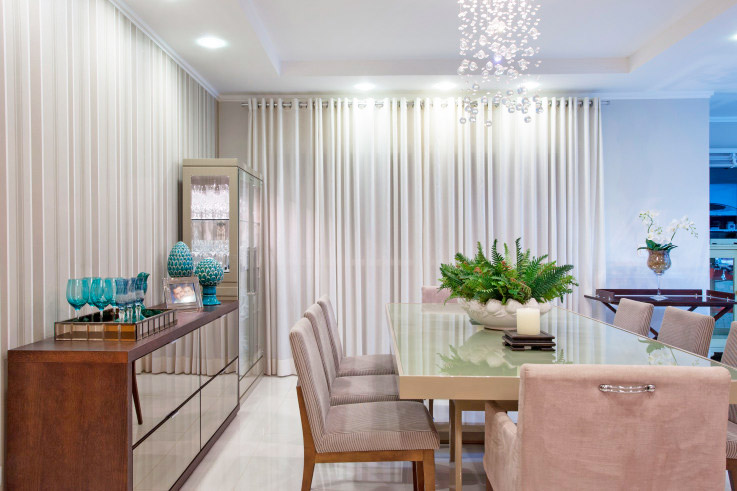 Cortinas e tecidos pesados compõem esta sala de jantar projetado pelo escritório OMK Arquitetura em Maringá (PR).