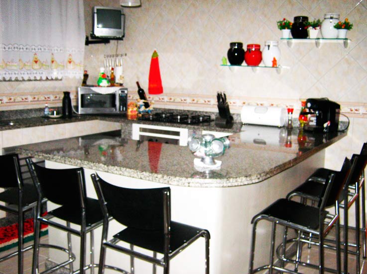 Neide Fernandes ficou encarregada da decoração da sua cozinha, de 14,60 m². A bancada é o que mais gosta no ambiente, por deixa-lo funcional, com tudo de fácil alcance. O ambiente ainda conta com uma despensa.