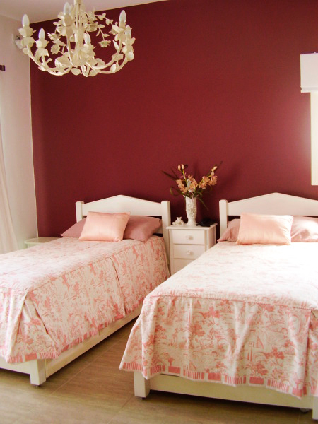 CASA NO INTERIOR DE SP. Este outro quarto da casa projetada por Rosane Aguiar recebeu duas camas de solteiro. O ambiente, de 13 m², traz as paredes escuras (tinta acrílica fosca Suvinil cor Suco de Uva) e lustre de ferro branco.