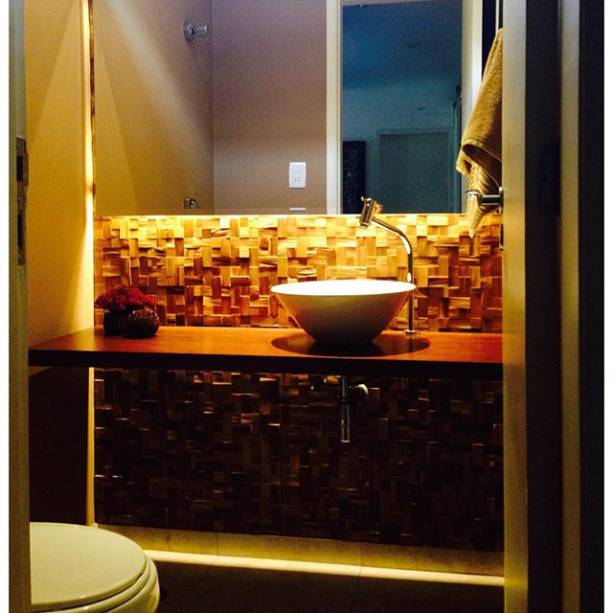 No lavabo desta casa em São Paulo (SP), as proporções diminutas (menos de 2 m²) não impediram do espaço ter charme e bom gosto. O piso escolhido foi o porcelanato Portobello e a pintura acrílica na cor Mousse de Café, da Coral. “A bancada é de madeira maciça em ipê”, explica a arquiteta Carmem Ávila, que assina o projeto.