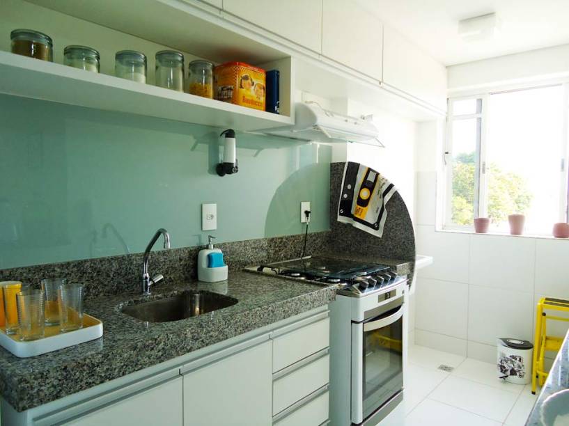 Enderson Vasconcelos e a namorada, Tatiany Alencar, projetaram esta cozinha. Como ambos não tinham experiência na área, pesquisaram bastante em revistas e blogs de decoração. Optaram, então, por deixar o ambiente de 5,74 m² com cores neutras. O que mais chama a atenção na cozinha é o vidro adesivado, que reveste a parede sobre a bancada.